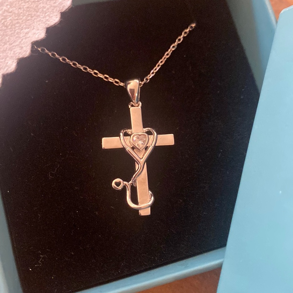 Sterling silver cross necklace with stethoscope wrapped around the cross